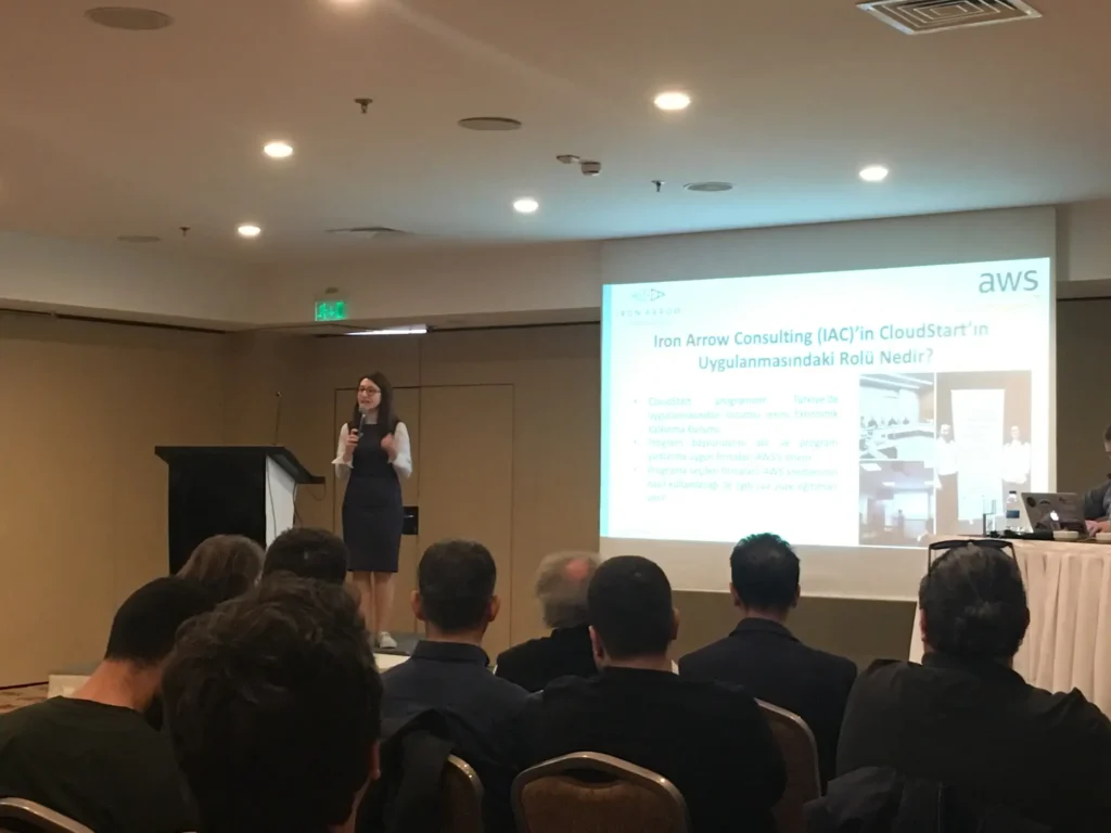 Woman presenting at conference with audience and AWS slide