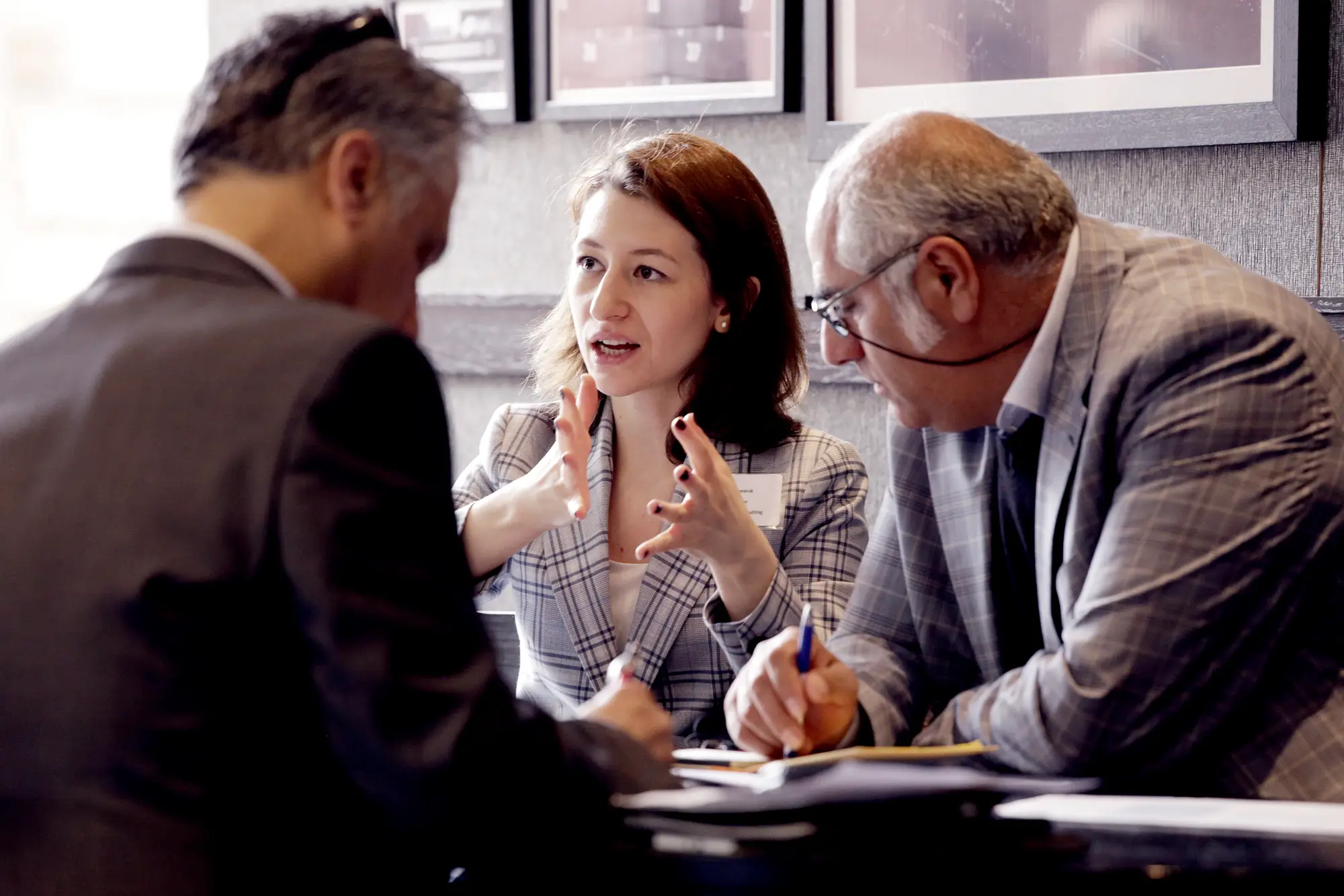 Businesswoman explaining strategy to two colleagues at table