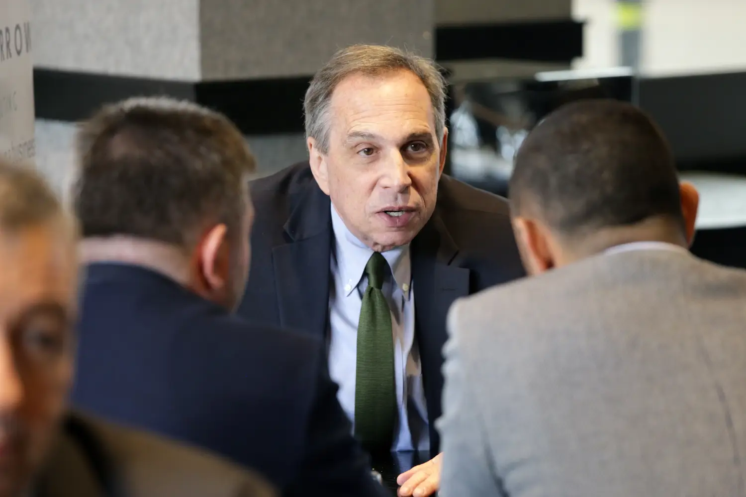 Business leader speaking intently during close team discussion