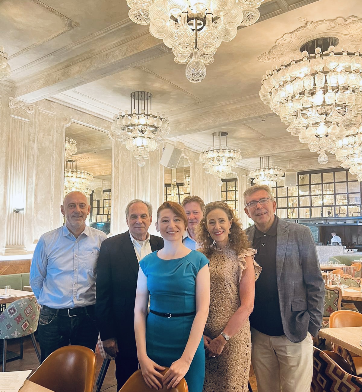 Group of professionals posing together in elegant restaurant interior